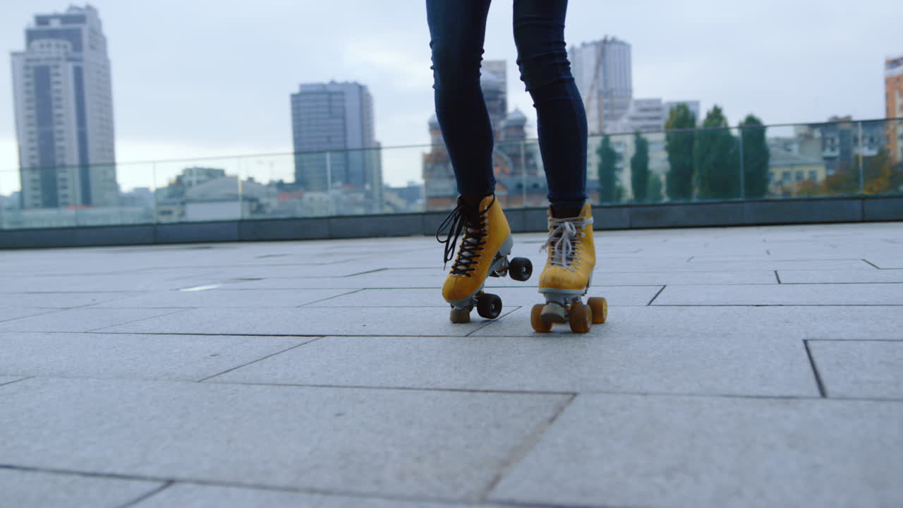 Kaki wanita melakukan gerakan dengan sepatu roda di luar ruangan. Pemain sepatu roda mengendarai di luar ruangan.