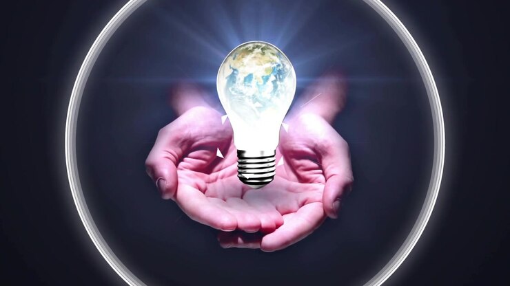 Contorno triangolare che pulsa, mani adulte a coppa che si sollevano a formare un anello, tenendo una lampadina a forma di Terra, mostrando la tecnologia