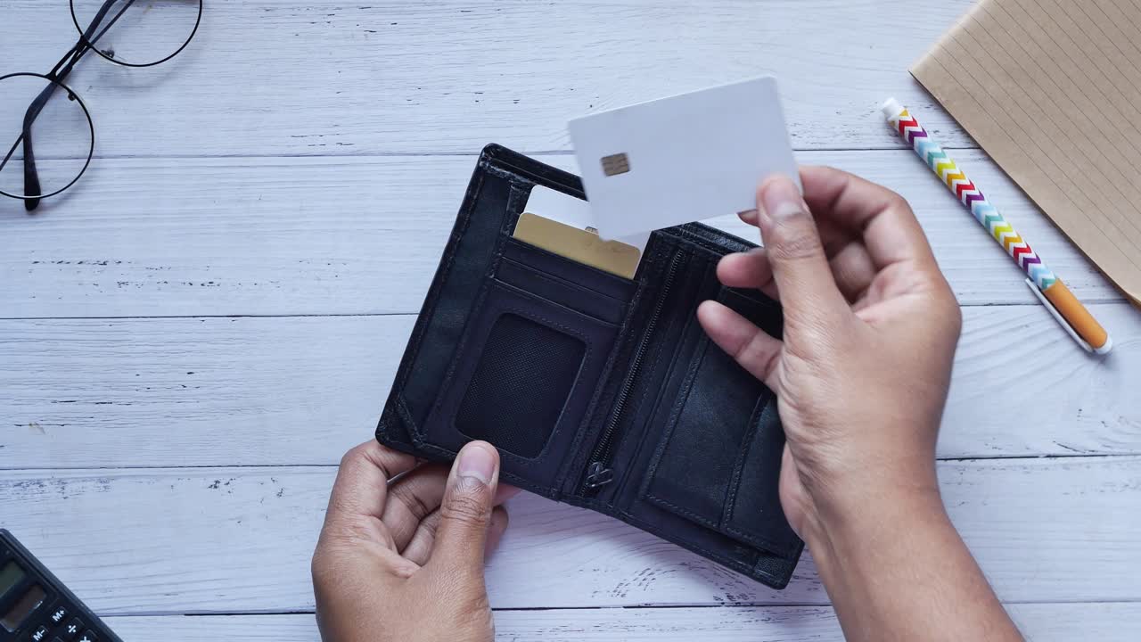 hombre con la mano sacando una tarjeta de crédito de una billetera