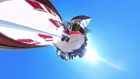 little tiny planet 360 small world view of a man walking alone on street through village in 4k