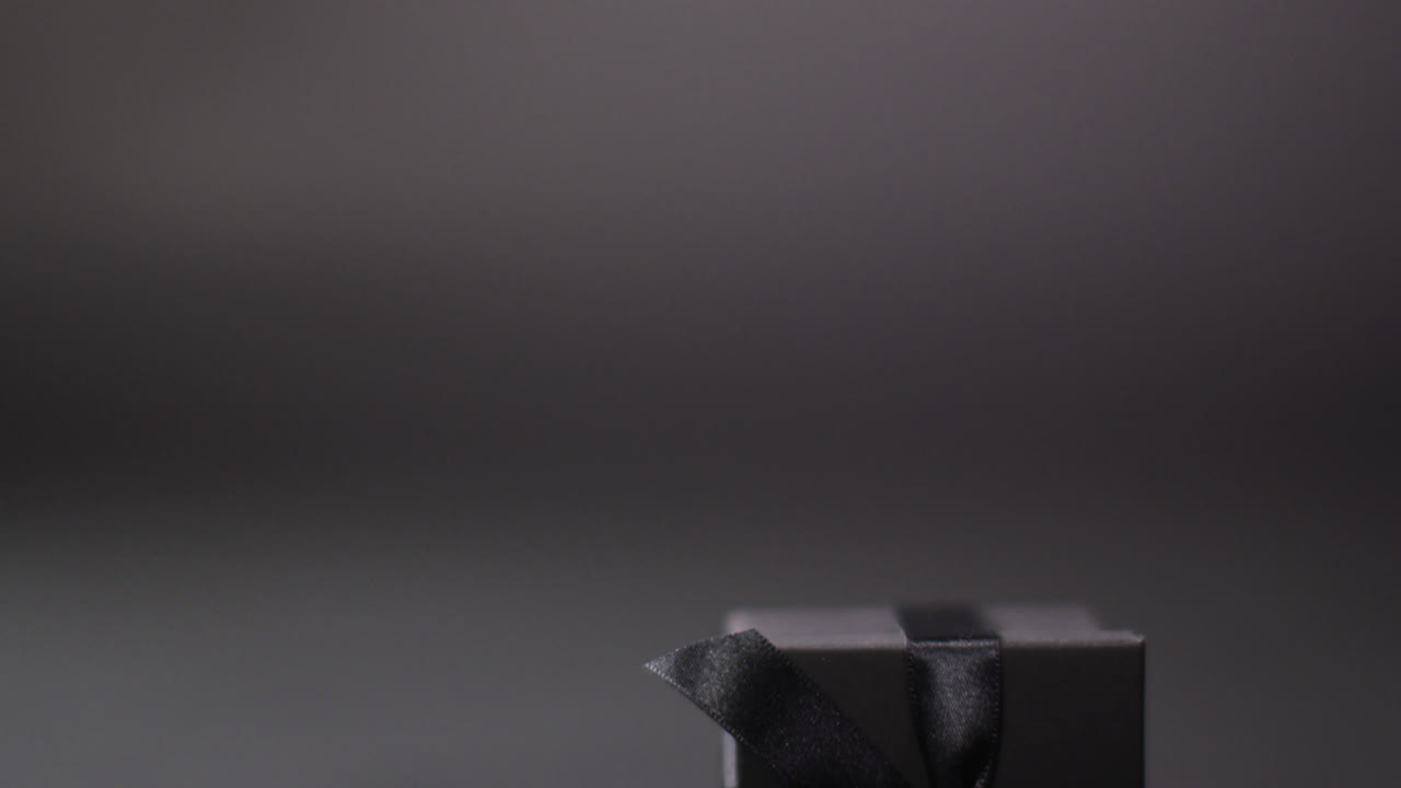 черная подарочная коробка с черной лентой на темно-сером фоне с местом для копирования
