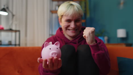 happy woman holding piggybank and putting in one dollar, save money, investment, savings, economy