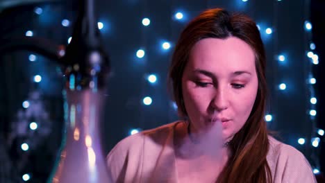 woman smoking hookah in a night setting