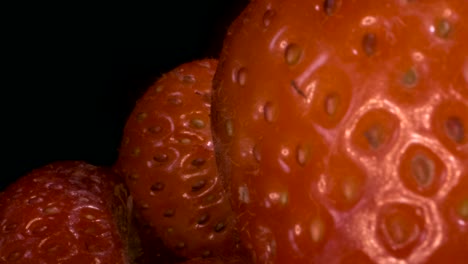 rotate of red strawberries on black background. close-up, camera rotation 360 degrees.