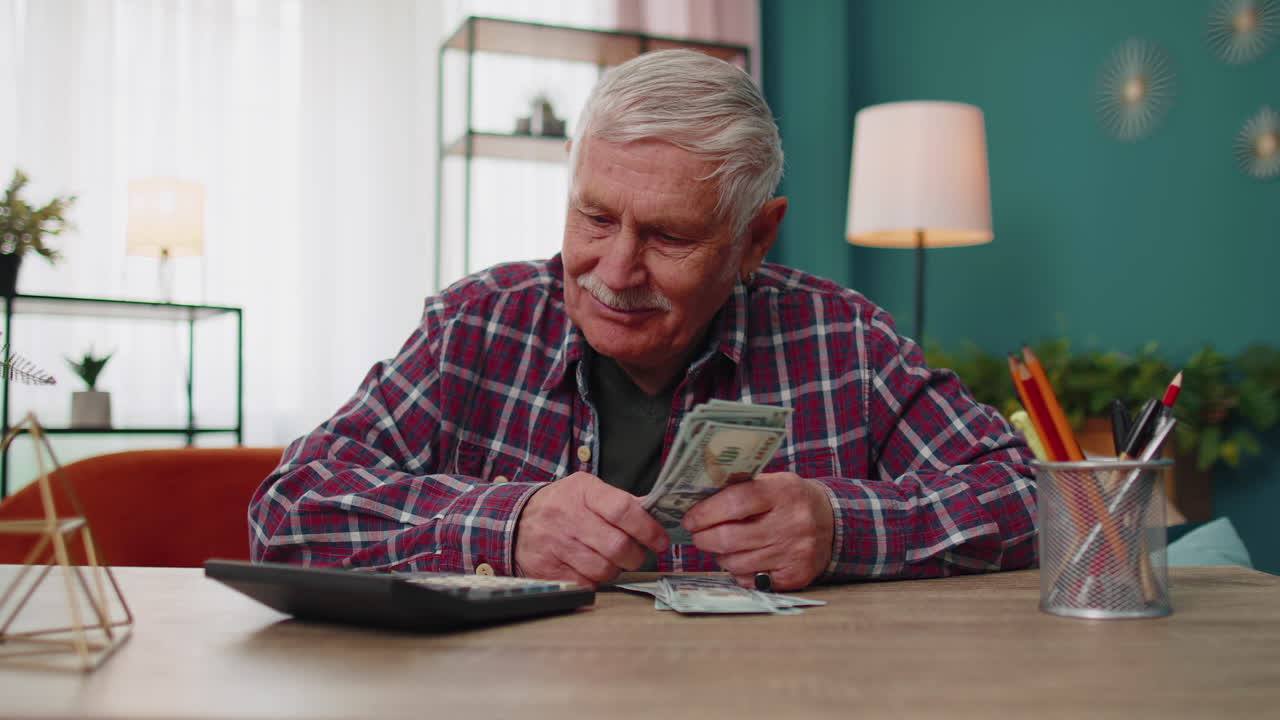 Happy grandfather man counting calculating cash money dollars planning expenses financial budget