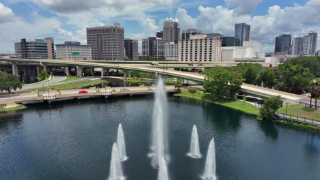 splashing fountain of lake in front of elevated interchange roads in orlando city, usa