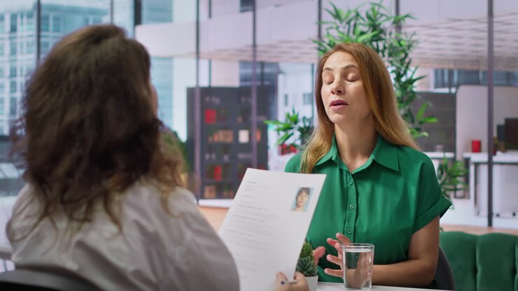 Applicant presents cv to a business recruiter during a structured job interview
