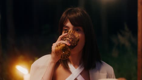 woman enjoying a drink outdoors at night