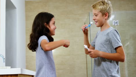 hermanos cepillándose los dientes en el baño