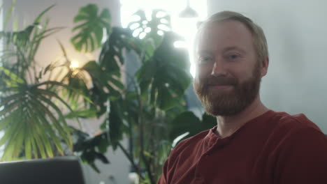 portrait of cheerful man with laptop at home