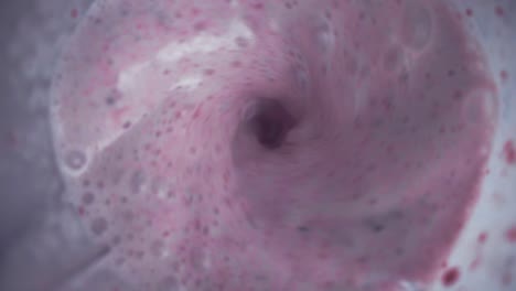 smoothie blended in slow motion shot from above using fruit strawberries, bananas and yoghurt