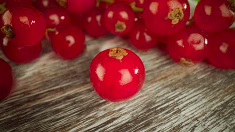 una macro muy cercana de una grosella roja en una mesa de madera.