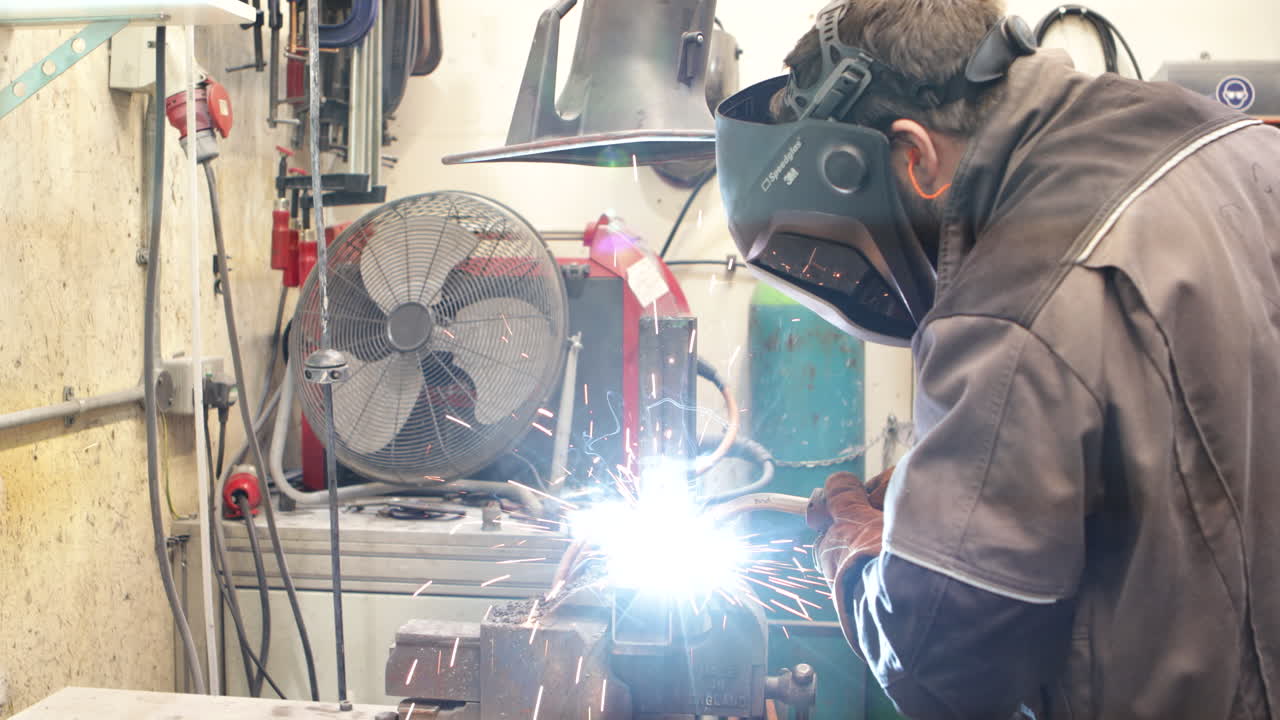 미그 용접기와 함께 강철 튜브를 용접하는 작업자