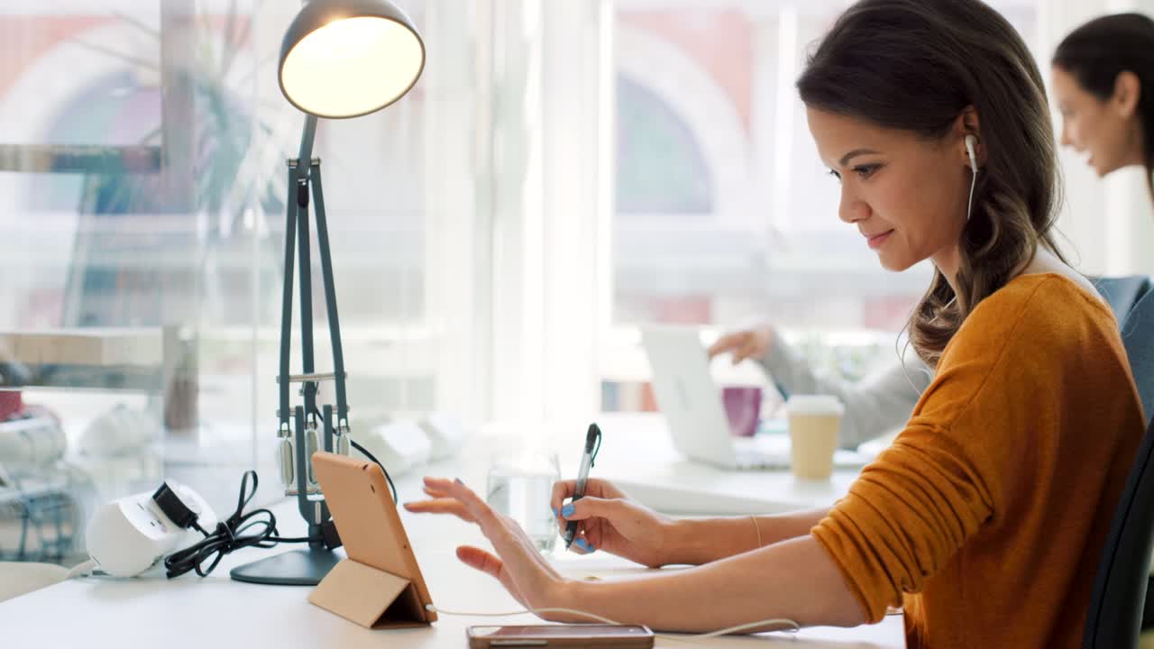 4k video footage of a businesswoman working on a digital tablet at her desk