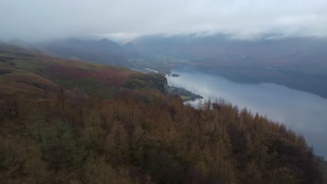 Aerial-drone-footage-in-4K-of-autumn-trees-with-cloud-and-a-lake-in-the-background