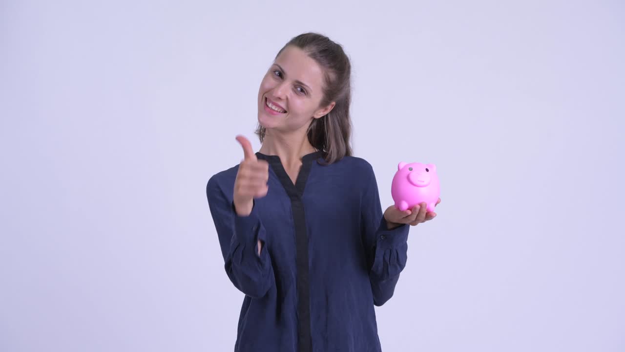 Happy young beautiful businesswoman with piggy bank