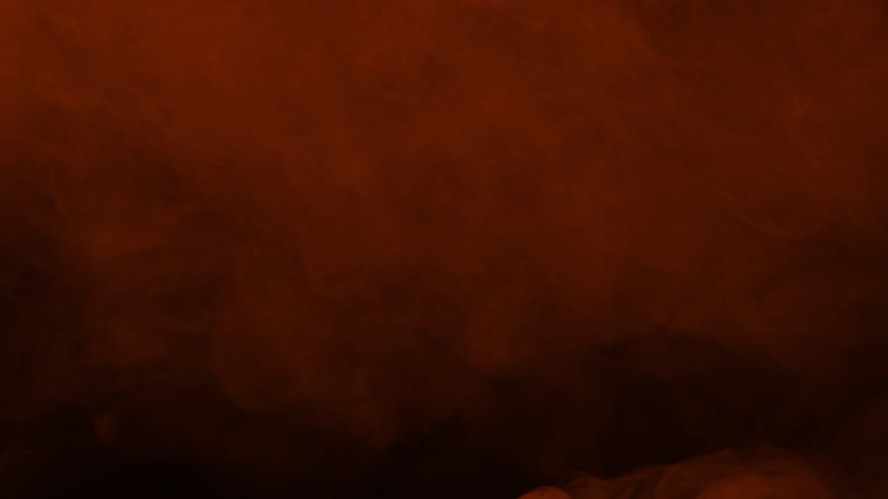 Una nebbia densa e spessa di braci arancioni riempie la parte superiore dell'inquadratura, creando un intenso effetto di calore su sfondo nero.