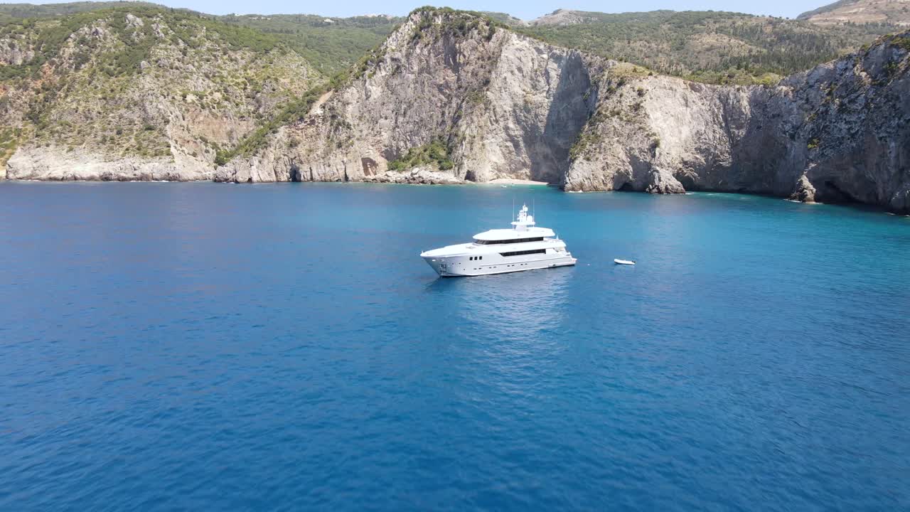 Lussuoso yacht bianco in un pittoresco panorama montano e marino in Grecia