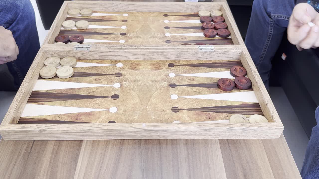 To personer spiller backgammon ved bordet