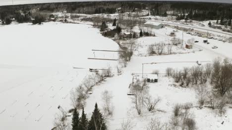 A-white-truck-driving-on-ice-roads-exits-the-roadway-on-frozen-boat-launch-and-travels-up-into-the-local-community