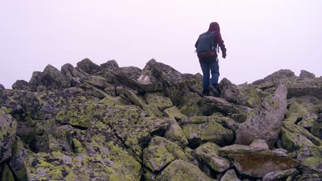 hikers walking up a mountain side in the rocky mountain side of romania