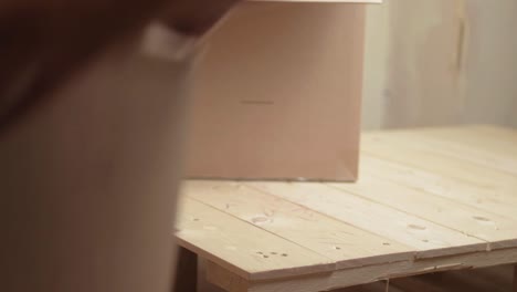 worker moving and stacking cardboard boxes on a wooden pallet