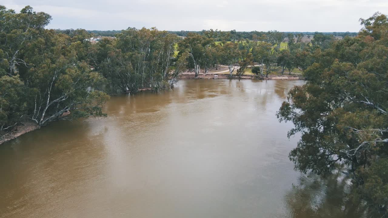 Drone aerial over the Murray river with trees on either side on a cloudy day in Australia