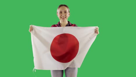 Attractive woman holding  a Japanese flag on chroma key green screen.