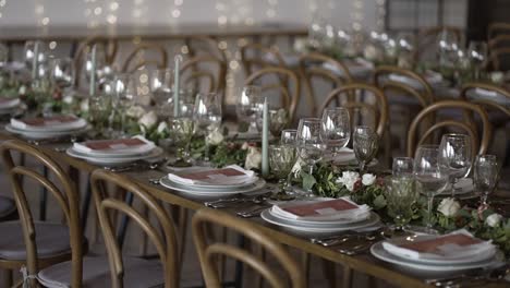 Elegant-Gedeckte-Hochzeitstische-Mit-Blumengirlanden,-Kerzen-Und-Funkelndem-Glasgeschirr