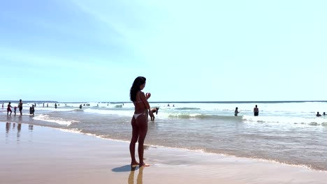 close view of woman gazes thoughtfully at the sea with her feet in the water