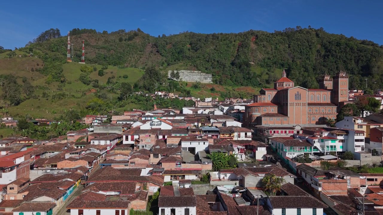 Vista aerea sui tetti di Gerico con una grande chiesa e lussureggianti colline verdi sullo sfondo.