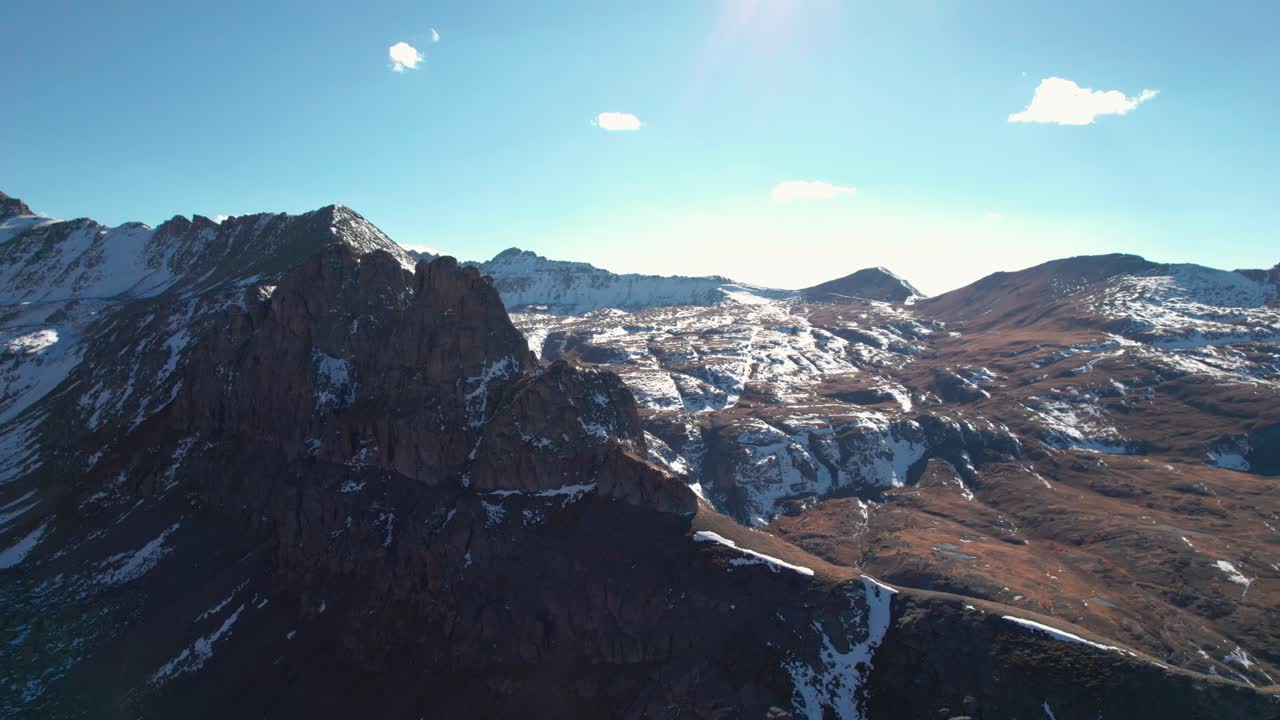 Drone som flyr rundt en topp av et snødekt fjell i San Juan-fjellene.