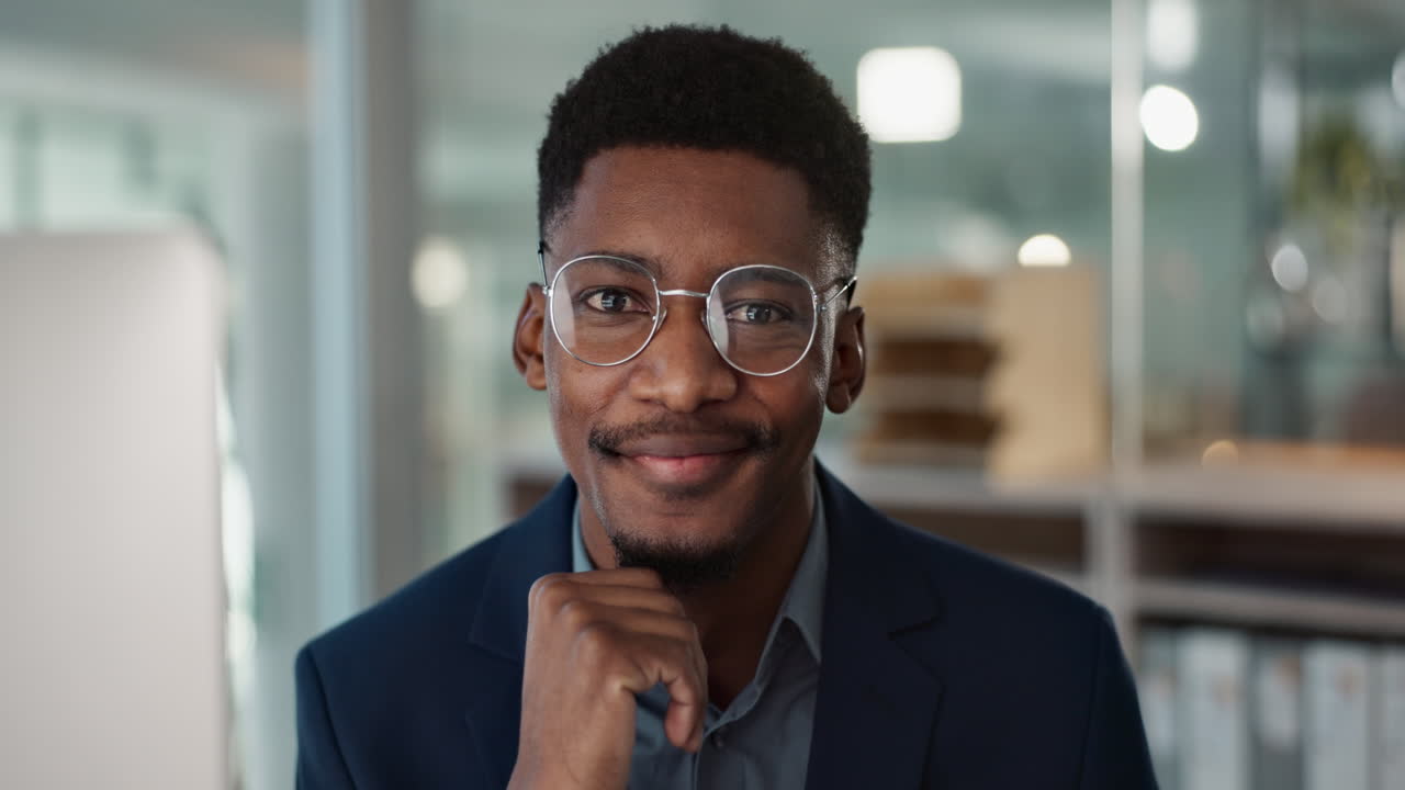 Young businessman, face and glasses in office