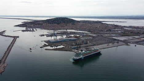 high aerial shot of sete city with a cruise ship in the port france cloudy day