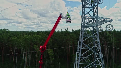 Electricista-En-Una-Plataforma-De-Trabajo-Elevada-Junto-A-La-Torre-De-Transmisión-Durante-El-Día