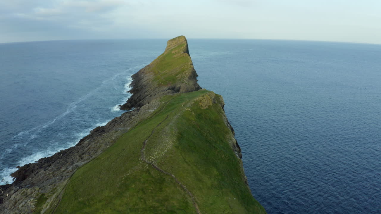 imágenes aéreas de drones de cabeza de gusanos en la bahía de rhossili en la península de gower en swansea, gales, con enormes acantilados