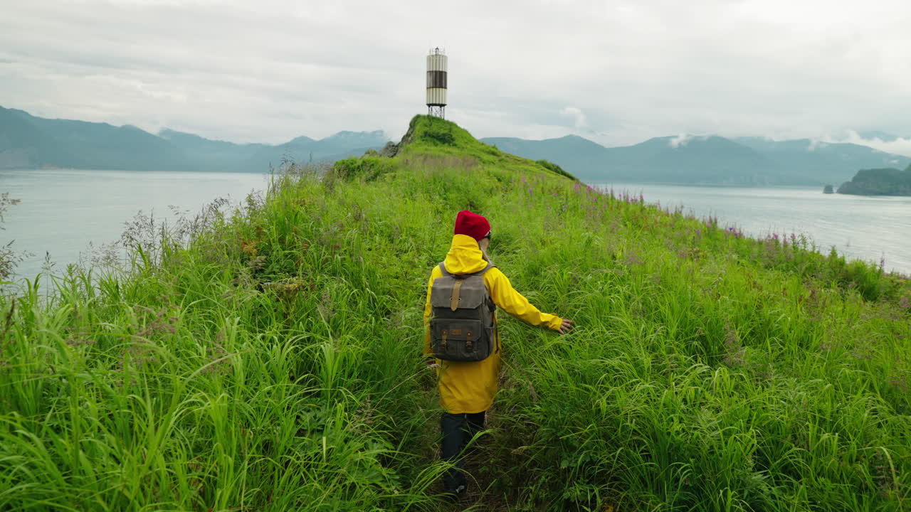 Person Hiking on a Coastal Trail near a Lighthouse