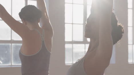 yoga-class-healthy-hispanic-woman-practicing-warrior-pose-with-group-of-beautiful-women-enjoying-healthy-lifestyle-exercising-in-fitness-studio-training-at-sunrise