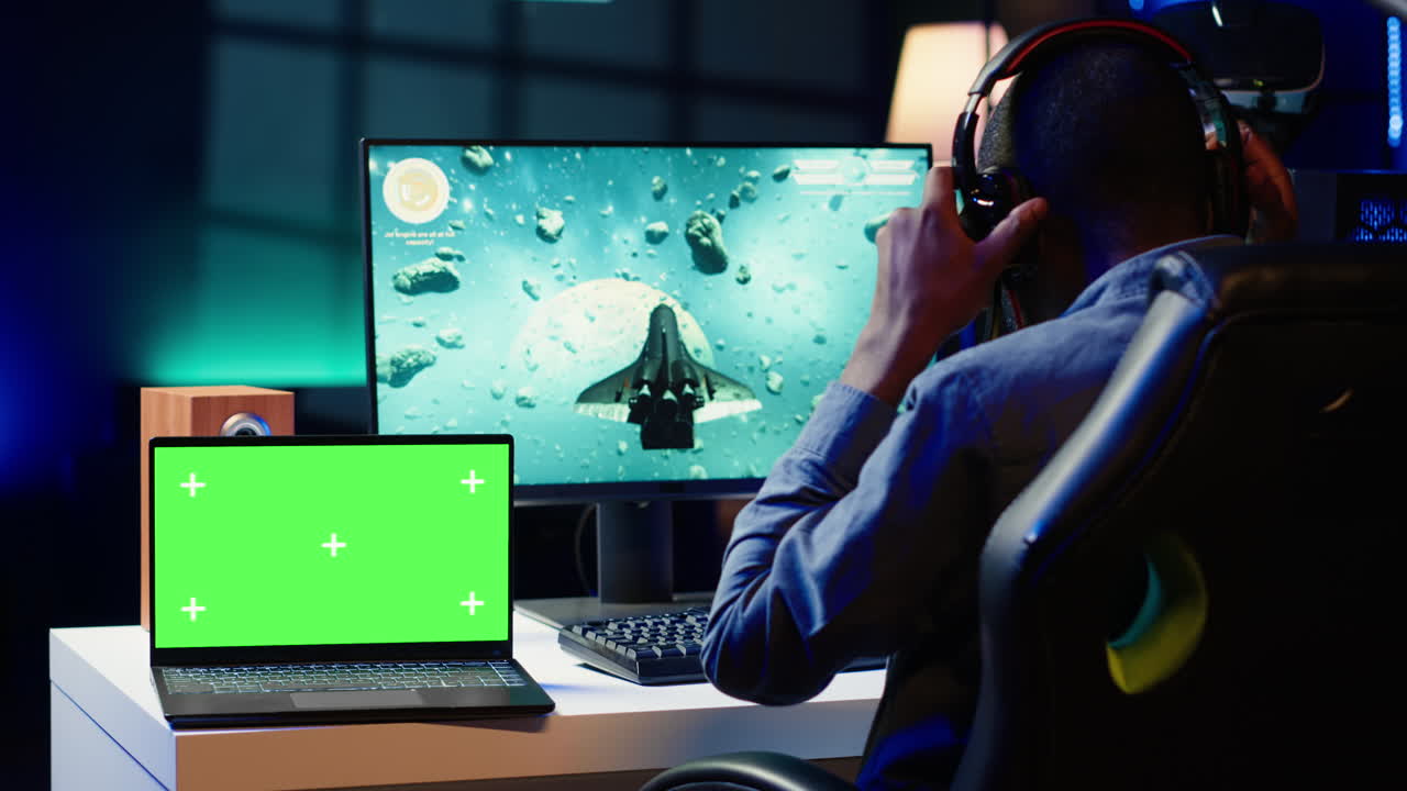 목표물을 타격하기 위해 크로스헤어를 사용하는 게이머 근처의 고립된 스크린 노트북