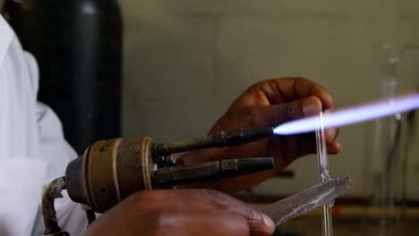 Close-up-of-male-worker-blowing-glass-in-glass-factory-4k