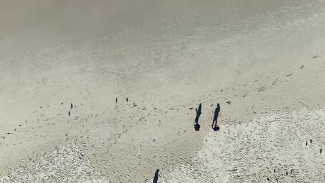 two people walking on a sandy beach