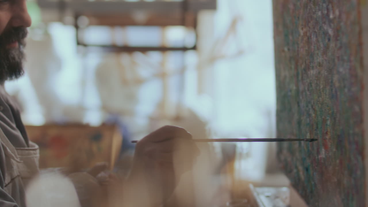 Painter Applying Details to Abstract Artwork on Canvas with Brush in Studio
