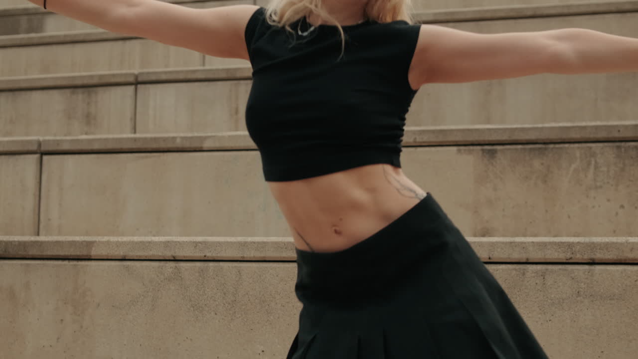 Young Blonde Woman Dancing Expressively on Concrete Steps