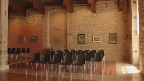 Filas-De-Sillas-Vacías-Dentro-De-La-Sala-De-Juntas-En-El-Ayuntamiento-Histórico,-Actualmente-Con-Una-Exhibición-En-Morella,-España