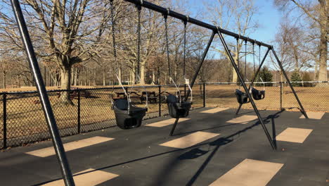 Empty toddler swing set in park, winter time