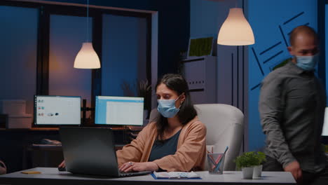 overworked entrepreneur with face mask against covid19 working in startup office