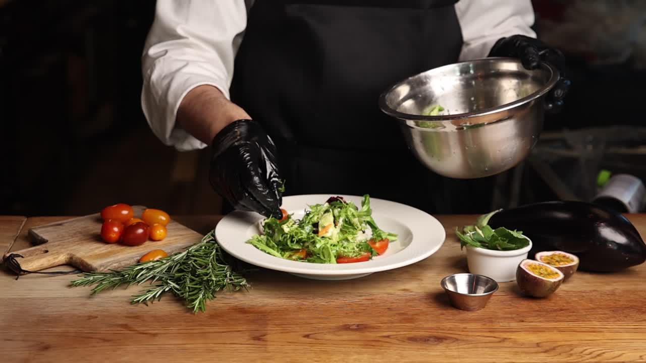 Chef Plating Fresh Green Salad with Vegetables on Wooden Table