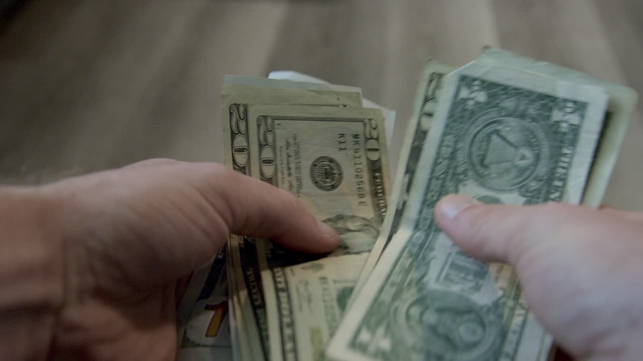 Conteggio di denaro contante a mano, banconote da dollaro americano spiegate contate a mano. Conteggio di denaro.