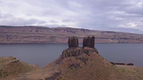 Aerial: Western sagebrush landscape with rock spires and wide river