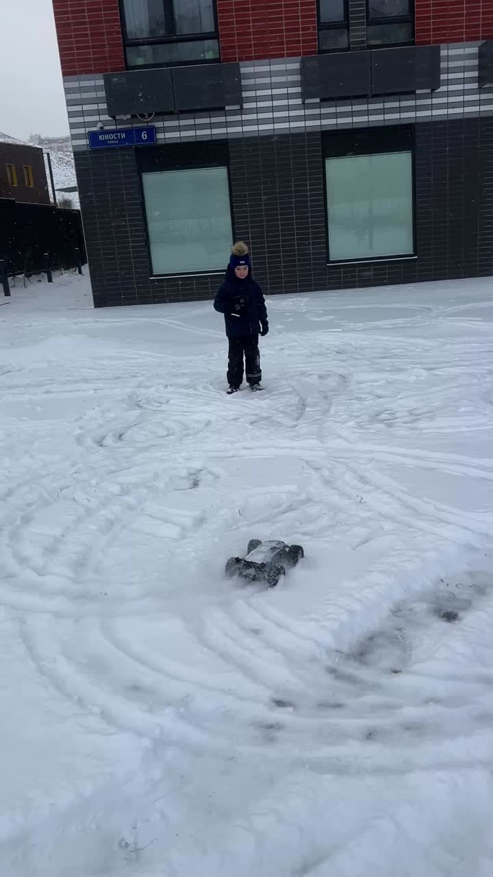 Child playing with an RC car in the snow